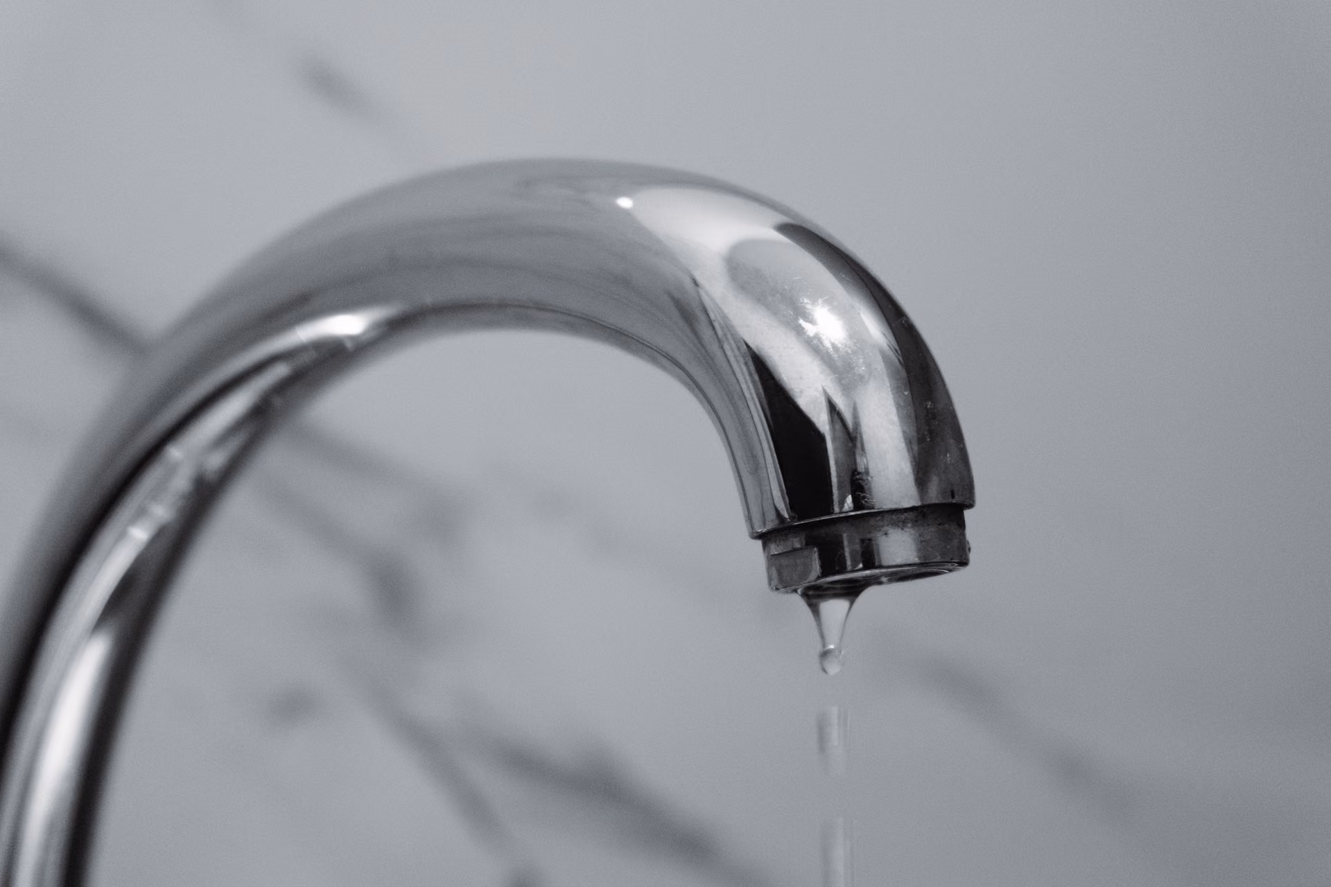 Rubinetto cromato del bagno da cui gocciola acqua